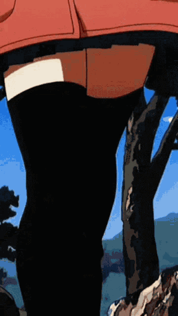 a person in a red jacket and black pants is standing in front of a tree