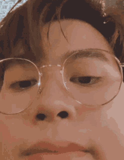 a close up of a person 's face with glasses