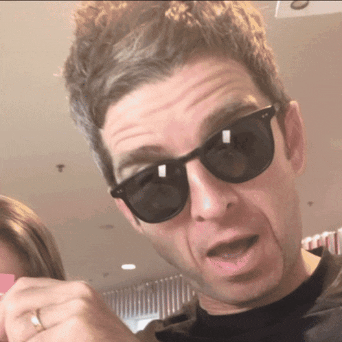 a man wearing sunglasses is making a face
