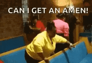 a woman in a yellow shirt is jumping over a pool table with the words `` can i get an amen '' .