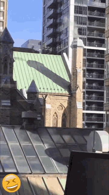 a building with a green roof and a smiley face on the roof