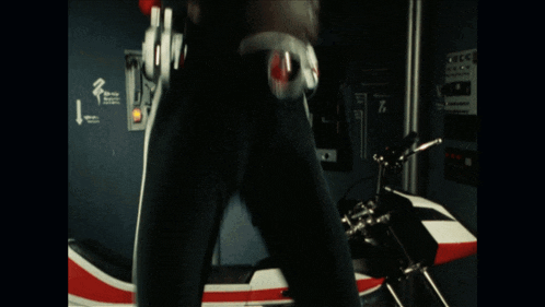 a person is standing next to a motorcycle with the number 2 on the wall behind them