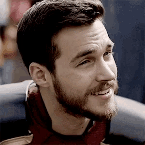 a close up of a man with a beard smiling .