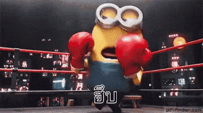 a minion wearing red boxing gloves is standing in a boxing ring .