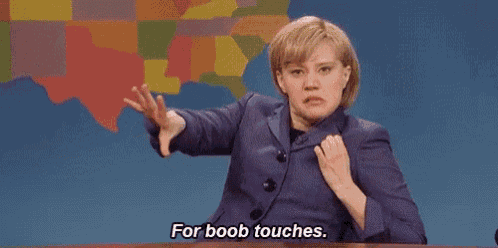 a woman in a purple suit is sitting at a table with her hands on her chest and says `` for boob touches . ''