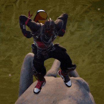 a man is standing on top of a rock wearing a helmet and holding a hat .