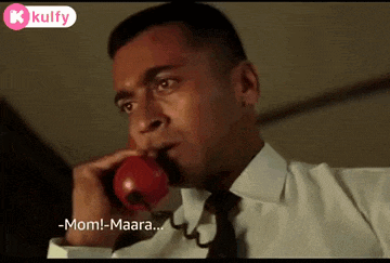 a man in a white shirt and black tie is talking on a red phone .