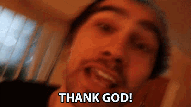 a man with a beard is smiling and saying thank god .
