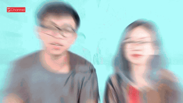 a man and a woman are sitting in front of a laptop with a sticker on it that says ' schannel '