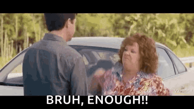 a man and a woman are standing next to each other in front of a car and the woman is yelling .