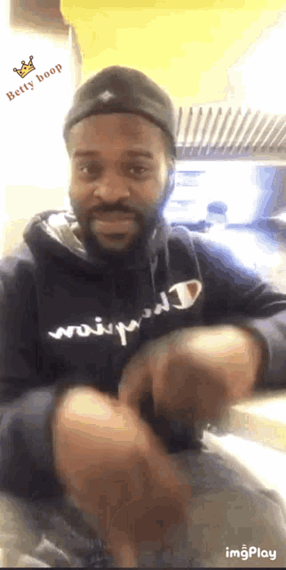 a man wearing a black hoodie that says ' betty boop ' on the bottom