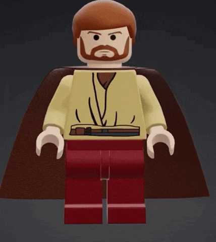 a lego man with a beard and cape is standing on a black surface .