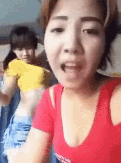 a woman in a red shirt is talking to another woman