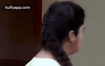 a close up of a woman 's face with a braided hair style .