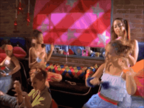 a group of people are gathered in a room with a pink and red wall