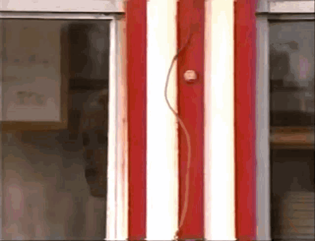 a red and white striped pole with lights on it