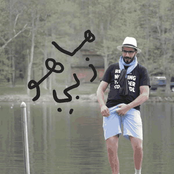 a man wearing a black t-shirt that says reading water is cool stands in front of a body of water