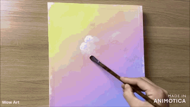 a person is painting a cloud on a canvas .