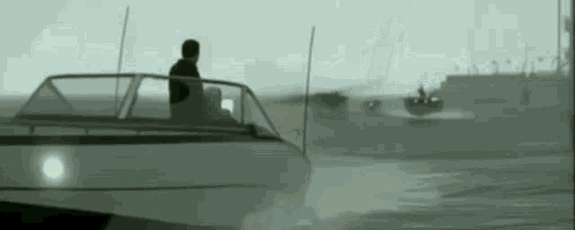 a man is sitting on a boat in the water .