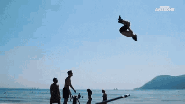 a group of people are doing a stunt on a beach and the words awesome are on the bottom
