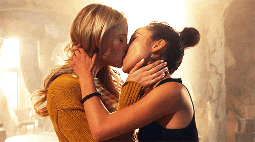 a couple of women kissing each other in a room