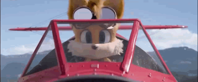 a cartoon character is flying a red airplane .