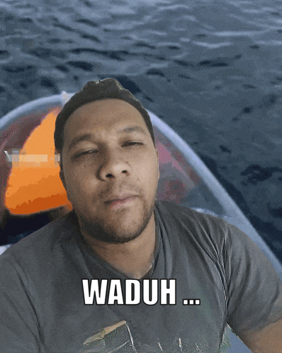 a man in a boat with the words waduh written on his shirt