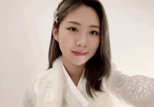 a woman in a white dress is taking a selfie .