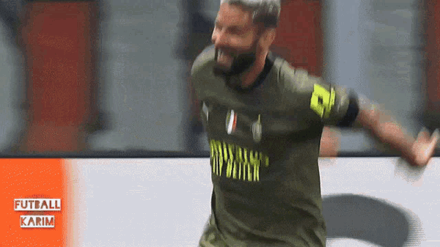 a soccer player wearing a green shirt with the word karim on the front