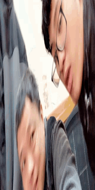 two men wearing glasses are taking a selfie and one of them is making a funny face