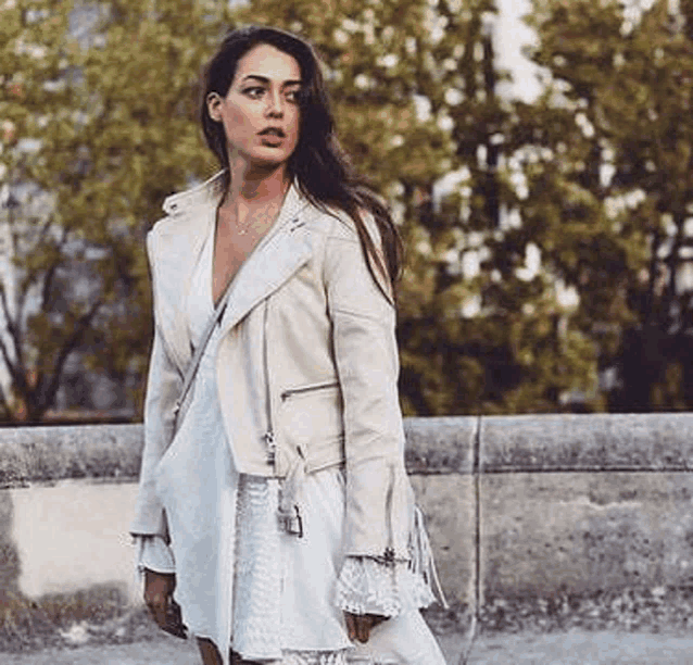 a woman is wearing a white dress and a white jacket .