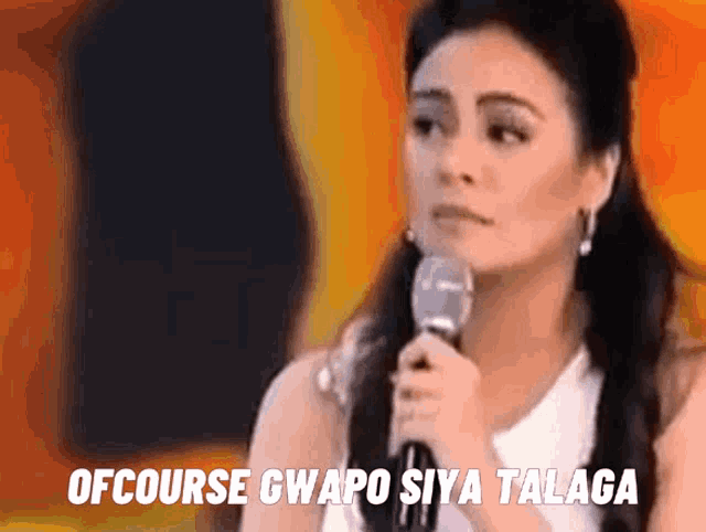 a woman speaking into a microphone with the words ofcourse gwapo siya talaga written below her