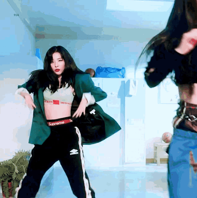 a woman in a supreme crop top and pants is dancing