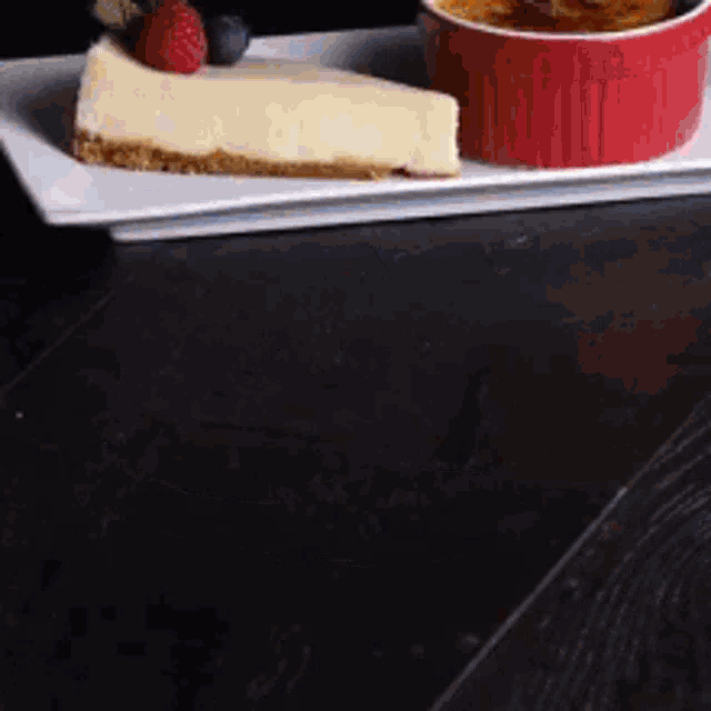 a slice of cheesecake is on a plate next to a bowl of dessert