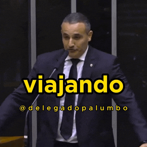 a man in a suit and tie stands in front of a microphone with the words esbanjando written in yellow
