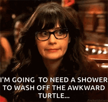 a woman wearing glasses is sitting at a table and making a face .