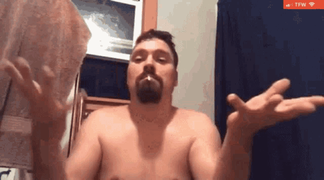 a shirtless man with a beard is smoking a cigarette in a bathroom