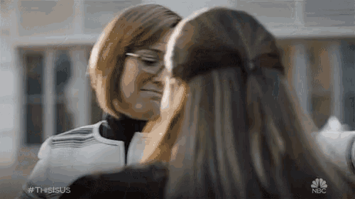 two women are looking at each other with a nbc logo in the background