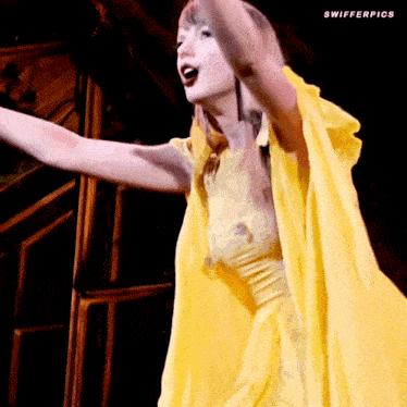 a woman in a yellow dress with swifterpics written on the bottom right