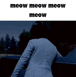a man in a blue suit is standing next to a car at night .