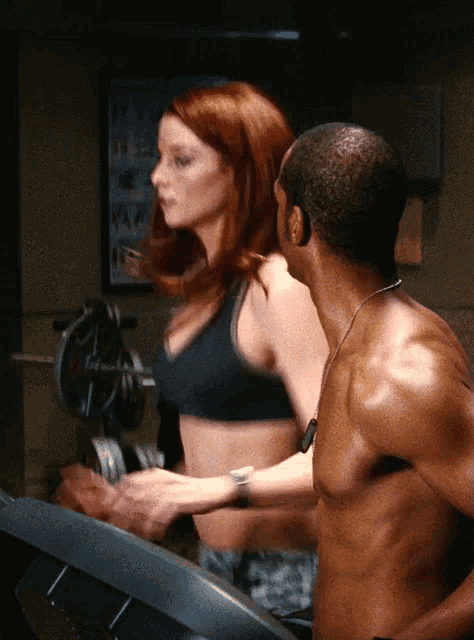 a man and a woman are walking on a treadmill in a gym