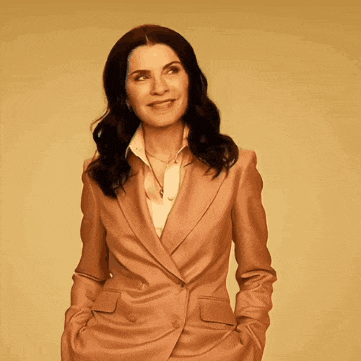 a woman in a brown suit is smiling and looking up
