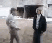 two men are standing next to each other in front of a truck .