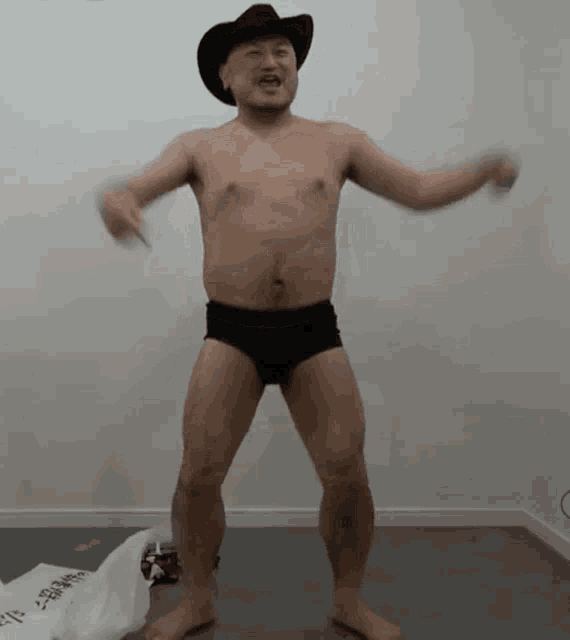 a shirtless man wearing a cowboy hat and black underwear