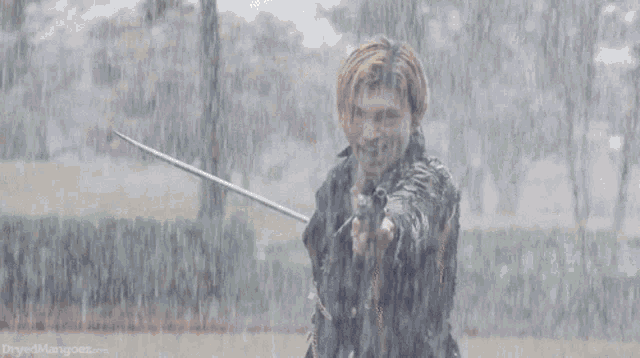 a man is holding a sword in the rain and the website dirtyedmagnolias.com is visible in the background