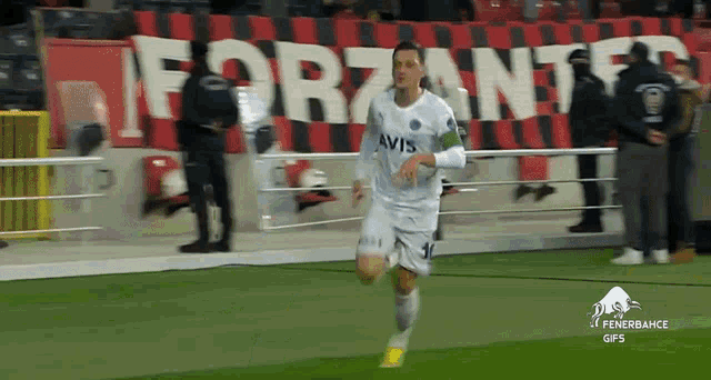 a soccer player wearing a white jersey with avis on the front