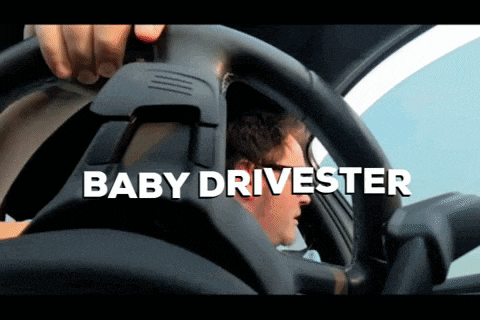 a man is sitting in a car with the words baby drivester behind him
