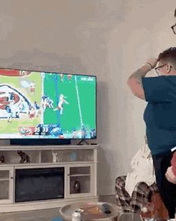 a man is standing in front of a television in a living room .