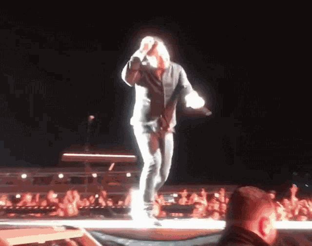 a man stands on a stage in front of a crowd