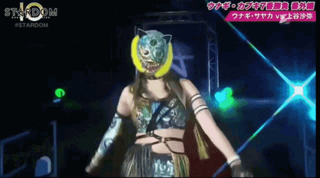 a woman in a cat mask is standing in front of a stardom sign
